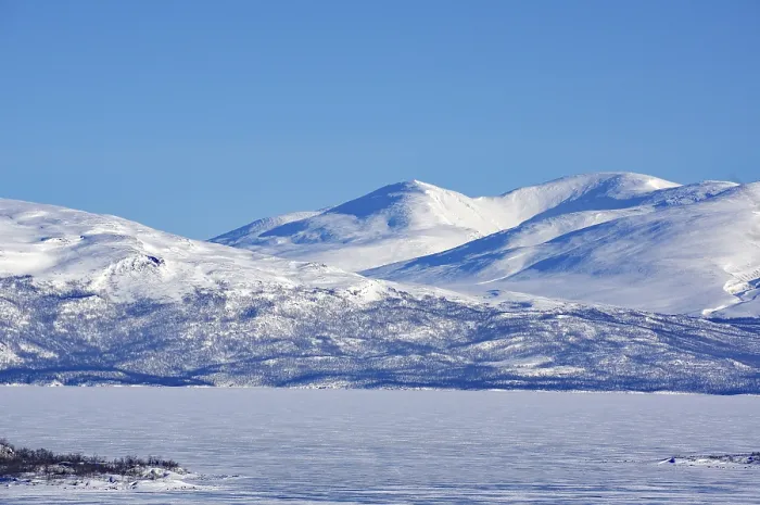 Framed Print : Snow-capped mountains and a frozen lake under a clear blue sky