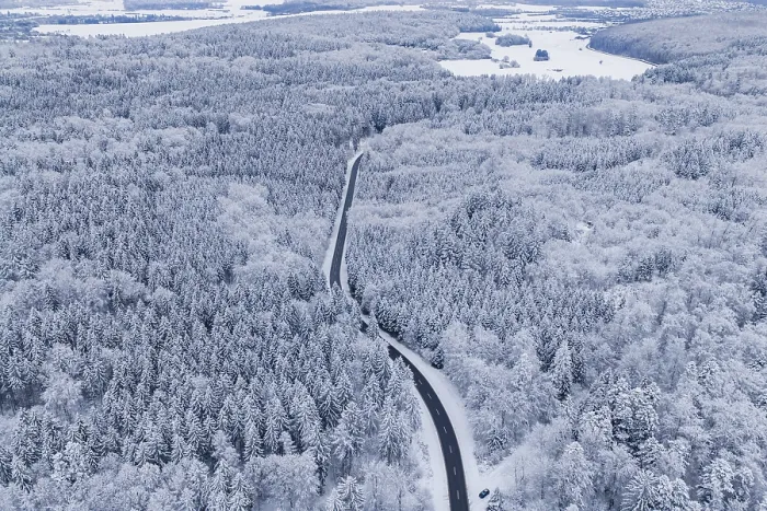 Framed Print : Snow-covered road leads through a vast winter forest