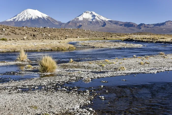 Framed Print : Snow-covered volcanoes Pomerape and Parinacota with icy river Framed Print : Snow-covered volcanoes Pomerape and Parinacota with icy river