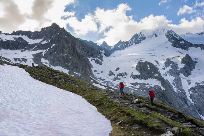 Framed Print : Snow field, hikers in front of snow-covered mountain peaks