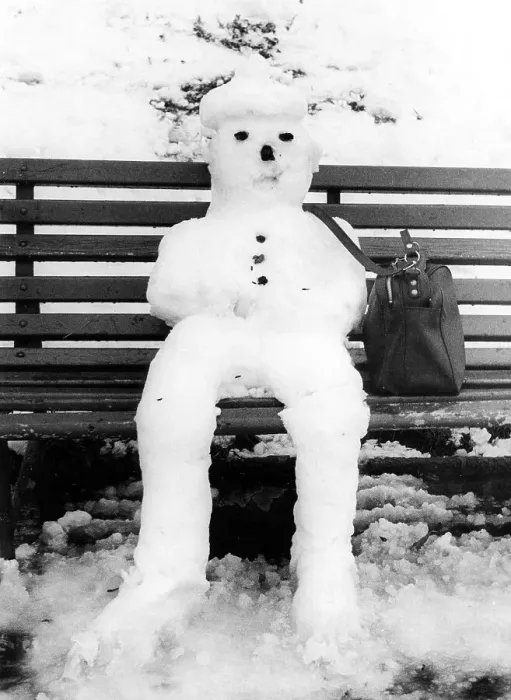 Framed Print : Snowman nit bag sits on bench ca