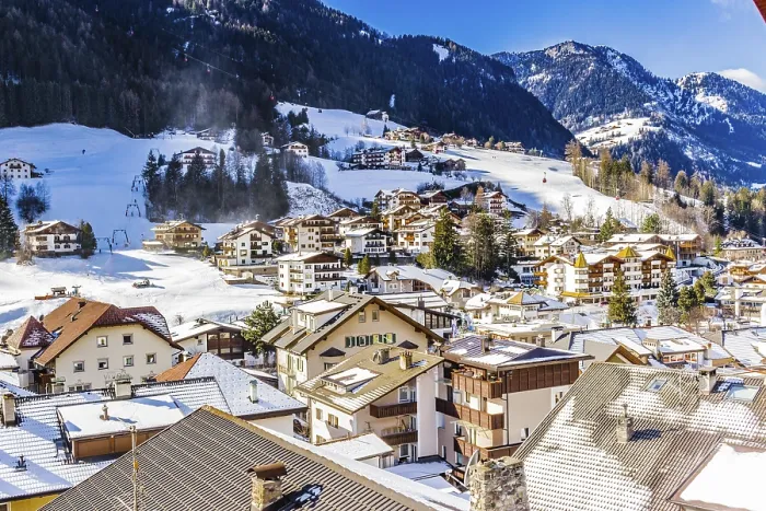 Framed Print : Snowy alpine village in Italy illuminated by sun with mountains in the background Framed Print : Snowy alpine village in Italy illuminated by sun with mountains in the background