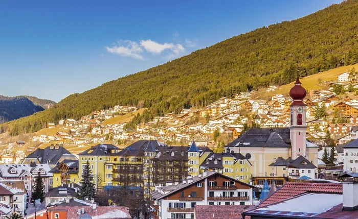 Framed Print : Snowy alpine village in Italy illuminated by sun with mountains in the background Framed Print : Snowy alpine village in Italy illuminated by sun with mountains in the background