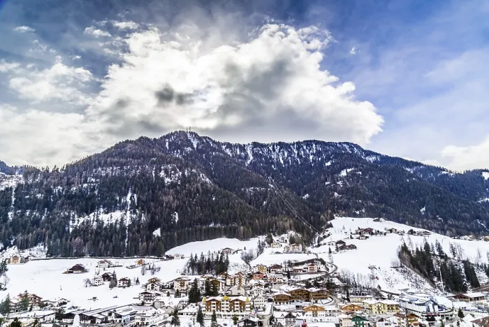 Framed Print : Snowy alpine village in Italy illuminated by sun with mountains in the background Framed Print : Snowy alpine village in Italy illuminated by sun with mountains in the background