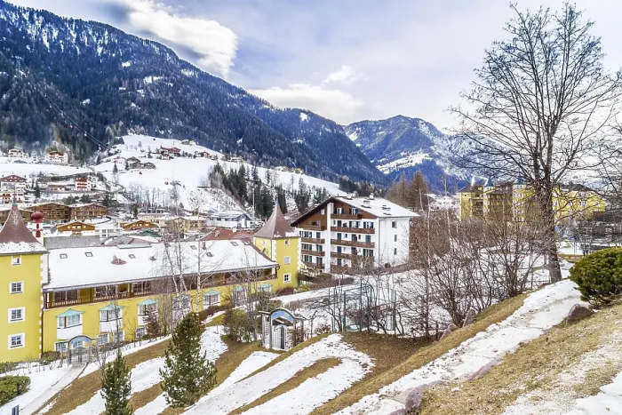 Framed Print : Snowy alpine village in Italy illuminated by sun with mountains in the background