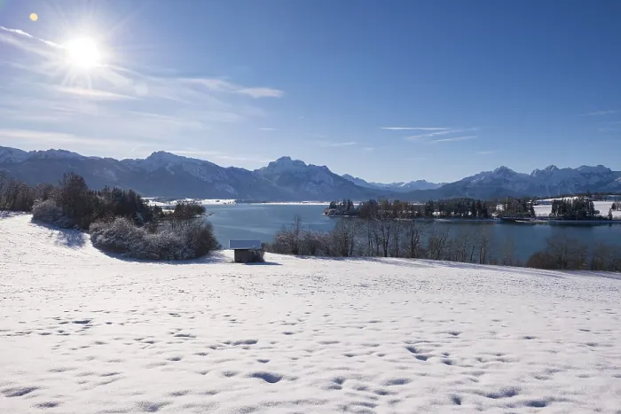 Framed Print : Snowy field with a view of a quiet lake and mountains under a bright sun Framed Print : Snowy field with a view of a quiet lake and mountains under a bright sun