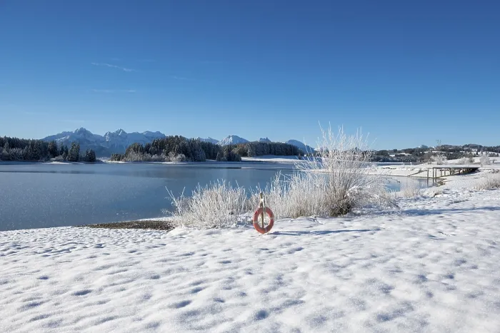 Framed Print : Snowy lake with a clear view of distant mountains