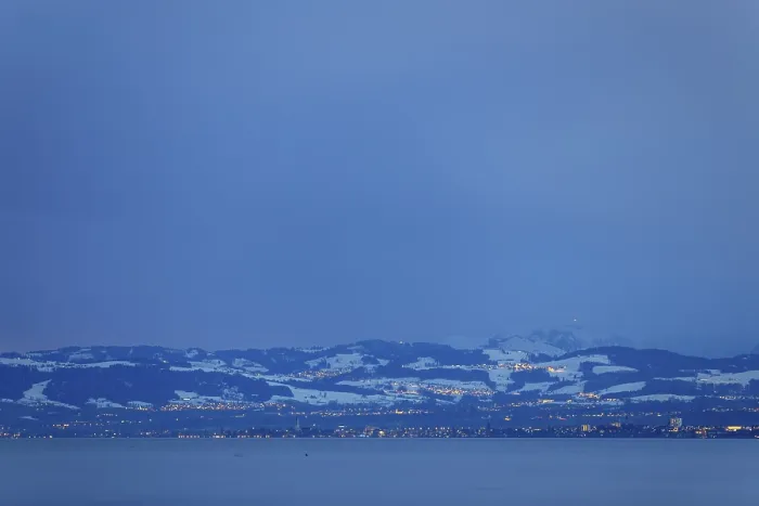 Framed Print : Snowy mountain landscape at dusk with view of lake and city lights