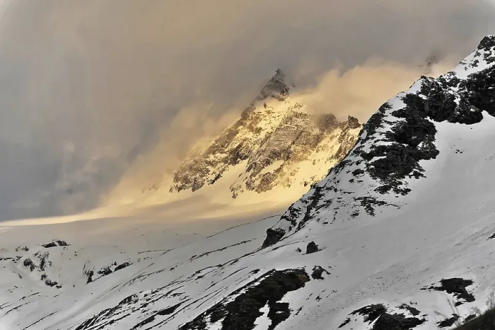 Framed Print : A snowy mountain peak rises majestically through dramatic clouds at twilight