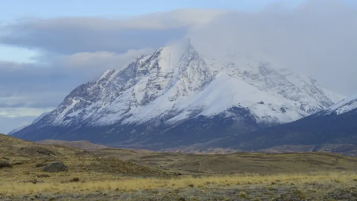 Framed Print : Snowy mountain peaks partially covered by clouds in a vast landscape