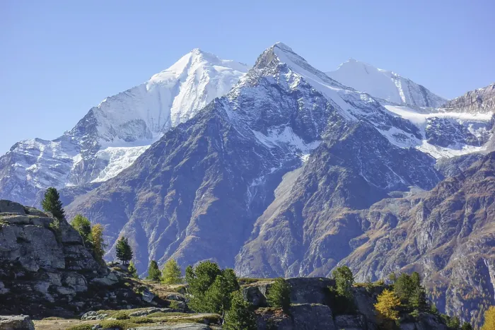 Framed Print : Snowy mountain peaks with rocks in the foreground under clear sky