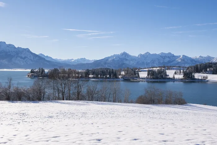 Framed Print : Snowy shore with a view of a quiet lake and mountains under a clear sky Framed Print : Snowy shore with a view of a quiet lake and mountains under a clear sky