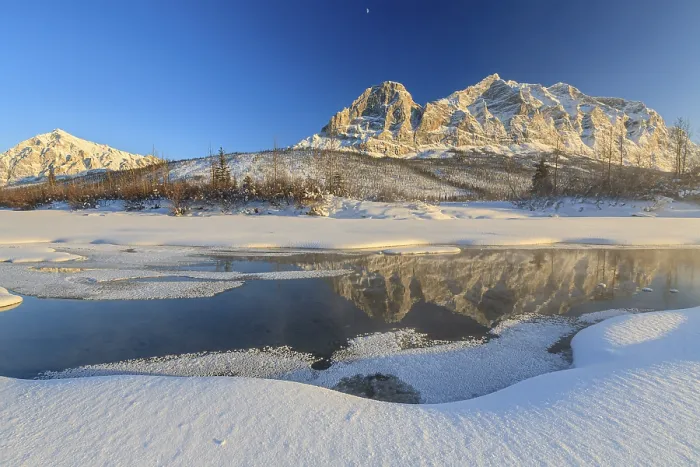 Framed Print : Snowy steep mountains reflected in frozen river Framed Print : Snowy steep mountains reflected in frozen river