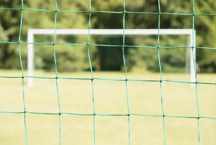 Framed Print : Empty soccer field seen through the net of the goal