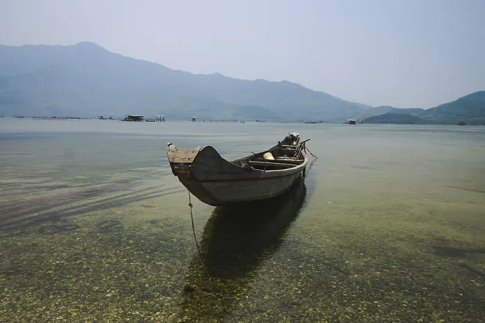 Framed Print : A solitary boat on still water with a clear mountain view Framed Print : A solitary boat on still water with a clear mountain view