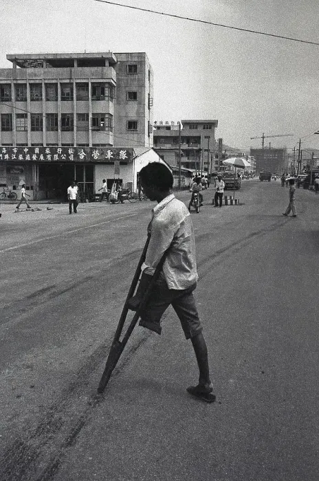 Framed Print : Southern provinces, China, circa 1982: An amputee crosses the road with the help of a crutch