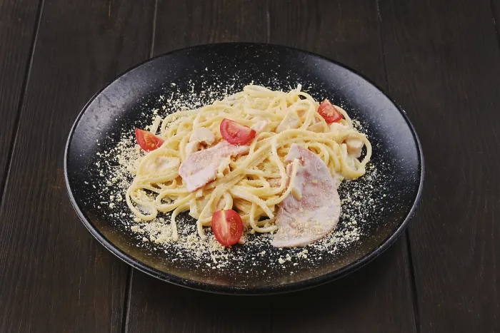 Framed Print : Spaghetti with ham and tomatoes sprinkled with grated parmesan