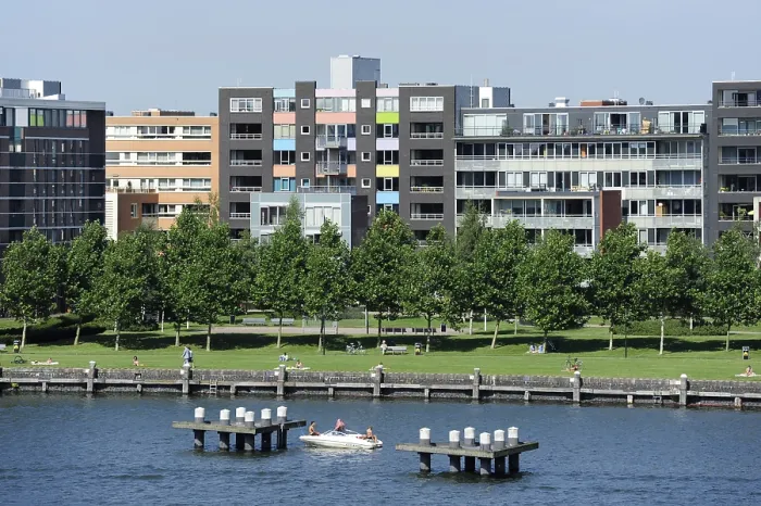 Framed Print : Speedboat in IJhaven harbour, behind it modern residential buildings on Java Island Framed Print : Speedboat in IJhaven harbour, behind it modern residential buildings on Java Island