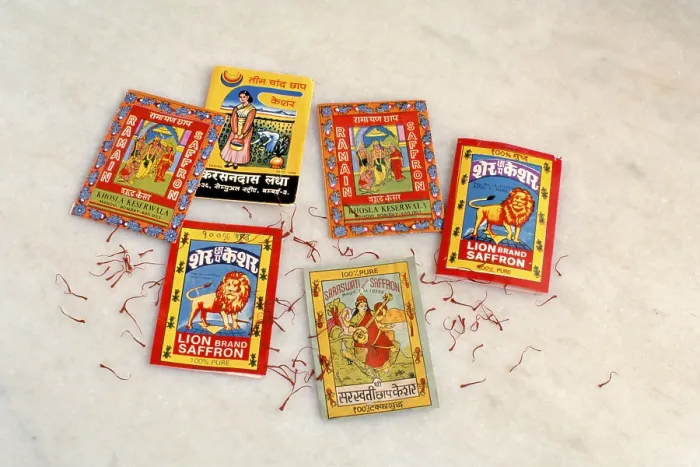 Framed Print : Spices, Tiny consumer packs of saffron with popular brand names often accompanied by images of Indian Gods