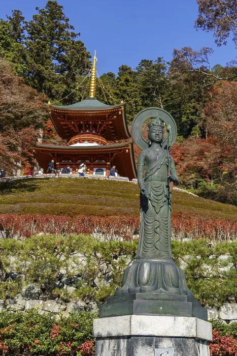 Framed Print : Spiritual image of a Buddha statue in front of a temple surrounded by autumn trees