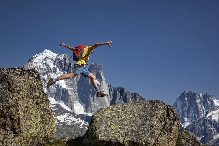 Framed Print : Sporty jump between two rocks against an impressive mountain backdrop Framed Print : Sporty jump between two rocks against an impressive mountain backdrop