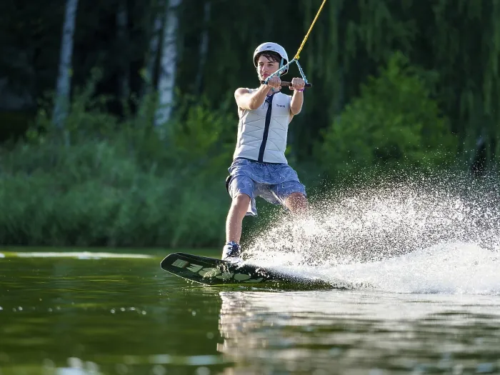 Framed Print : Sporty young man with helmet and waistcoat on wakeboard in lake