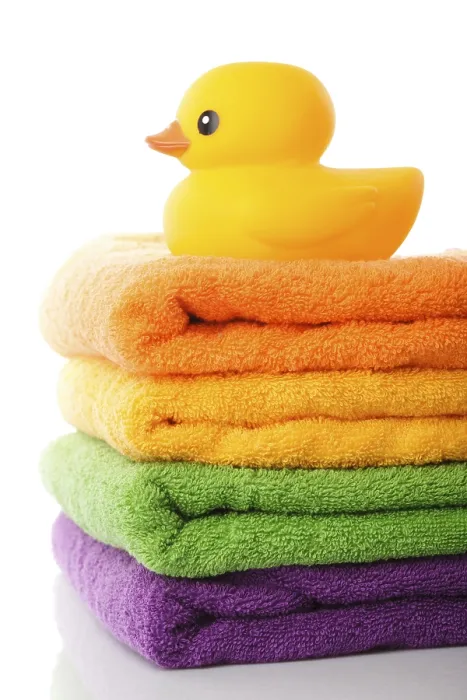 Framed Print : Stack of colorfull towels and yellow rubber duck isolated on white Framed Print : Stack of colorfull towels and yellow rubber duck isolated on white