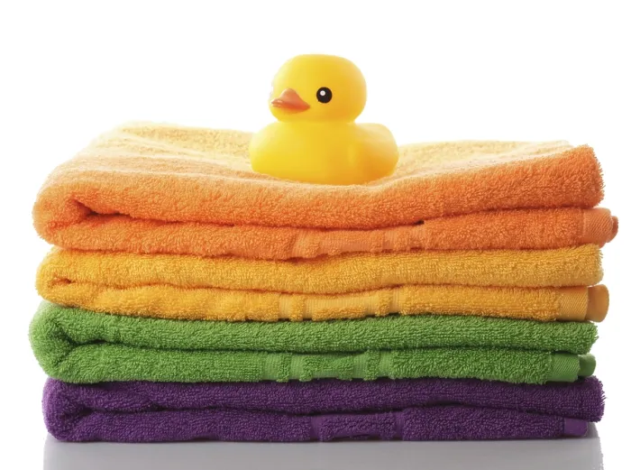 Framed Print : Stack of colorfull towels and yellow rubber duck isolated on white Framed Print : Stack of colorfull towels and yellow rubber duck isolated on white