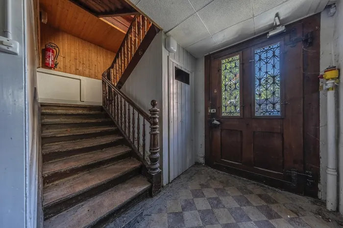 Framed Print : Staircase with main entrance door of a multi-storey residential building built in 1903 in front of demolition work