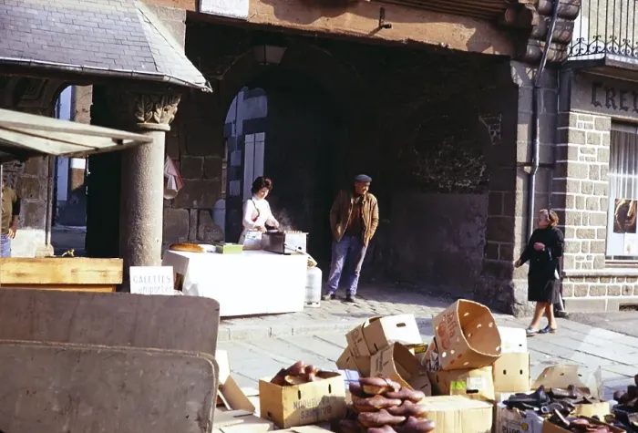 Framed Print : Stand eines Strassenhaendlers und Menschen auf dem Marktplatz von Quimper, Bretagne, Frankreich im Jahr 1974