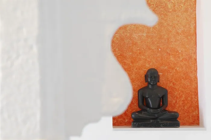 Framed Print : Statue of a black Buddha sitting meditating against an orange background