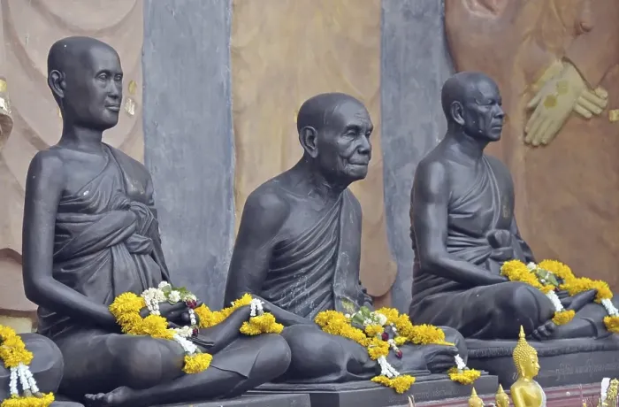 Framed Print : Statues of monks decorated with garlands of flowers