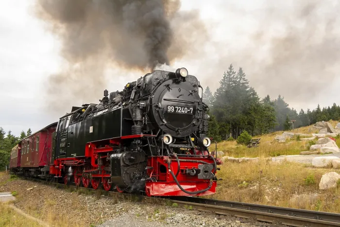 Framed Print : A steam train moves along the tracks in a rural area surrounded by trees and rocks Framed Print : A steam train moves along the tracks in a rural area surrounded by trees and rocks