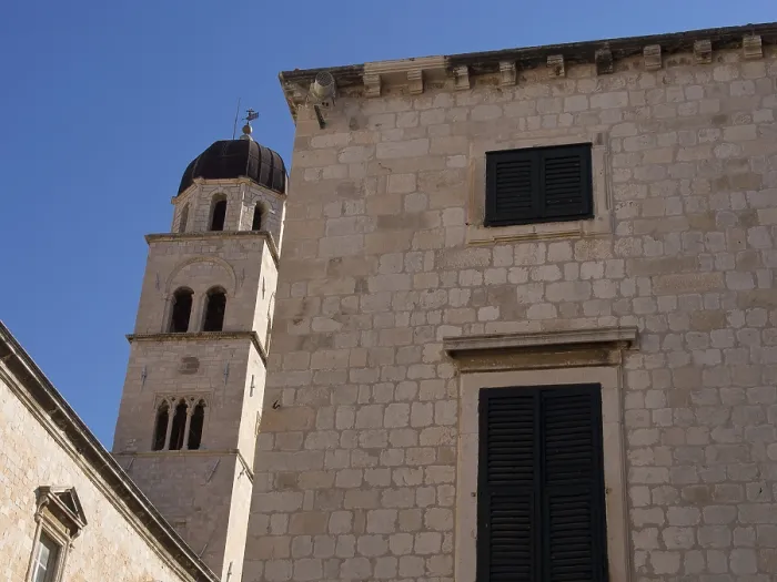 Framed Print : Stone building with shutters and bell tower in the background Framed Print : Stone building with shutters and bell tower in the background