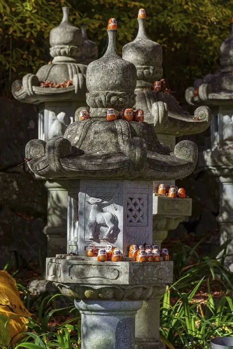 Framed Print : Stone lanterns decorated with small figures stand in a Japanese garden