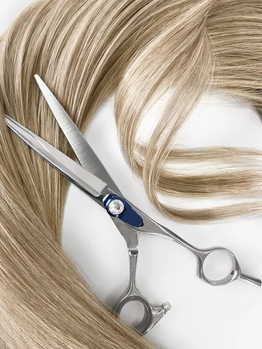 Framed Print : A strand of blond hair with scissors on a white background