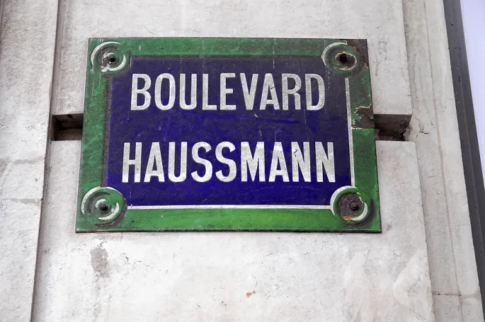 Framed Print : A street sign with the inscription Boulevard Haussmann in front of a grey wall