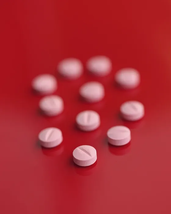 Framed Print : A striking image featuring several pink tablets casually dispersed on a saturated red backdrop