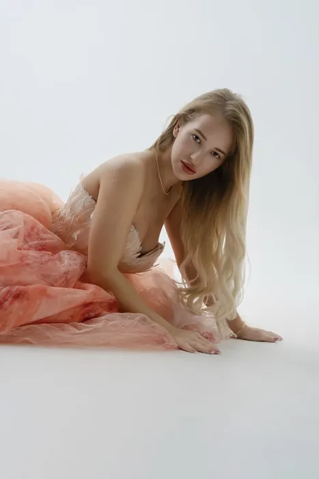 Framed Print : A stunning blonde woman kneels gracefully in a stylish studio