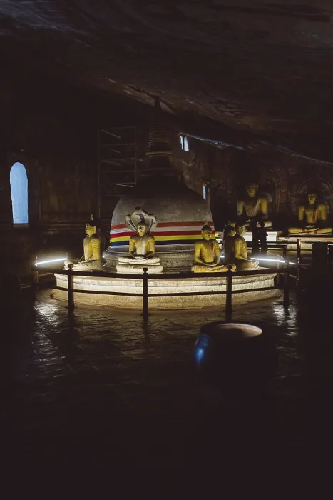 Framed Print : A stupa surrounded by Buddha statues in a dimly lit temple room