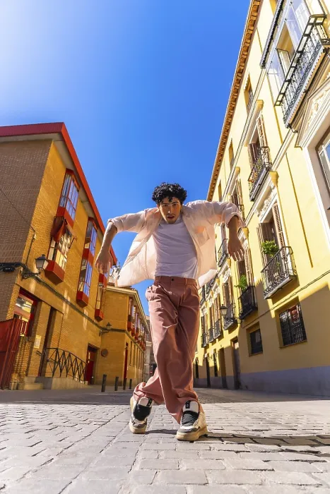 Framed Print : Stylish young man with intense expression executing a dynamic street dance move on cobblestones in a vibrant european