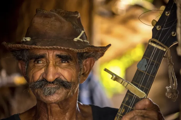 Framed Print : Sugar cane farmer in Valle de los Ingenios plays guitar for the tourists