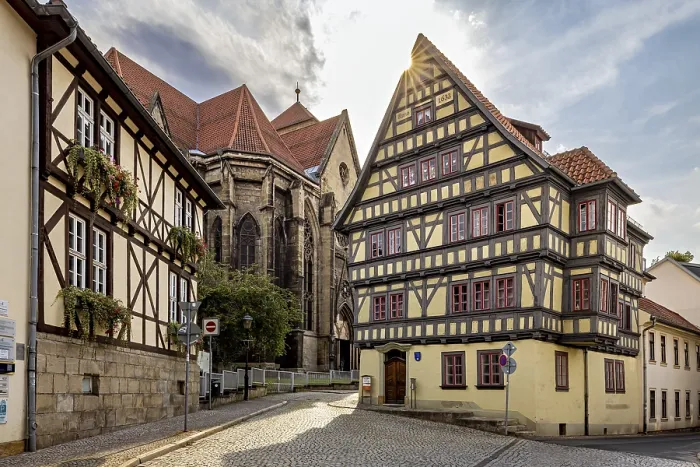 Framed Print : Sun-drenched street with half-timbered house and church Framed Print : Sun-drenched street with half-timbered house and church