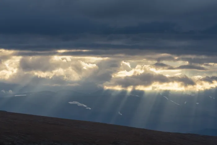 Framed Print : Sun rays fall through clouds in mountain landscape Framed Print : Sun rays fall through clouds in mountain landscape