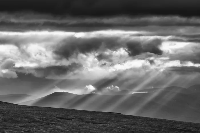 Framed Print : Sun rays fall through clouds in mountain landscape