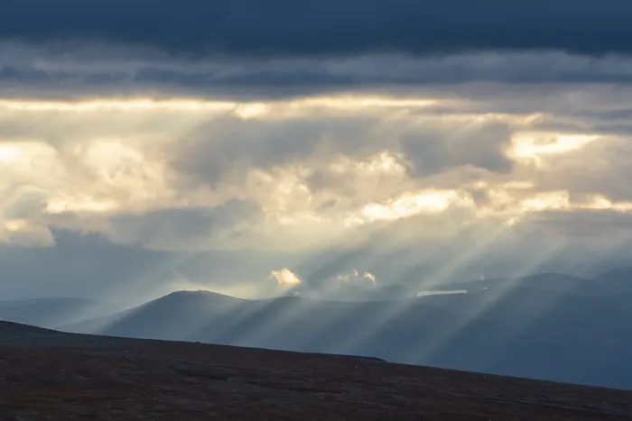 Framed Print : Sun rays fall through clouds in mountain landscape