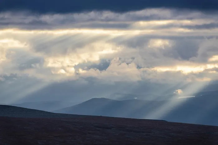 Framed Print : Sun rays fall through clouds in mountain landscape