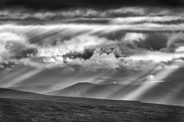 Framed Print : Sun rays fall through clouds in mountain landscape