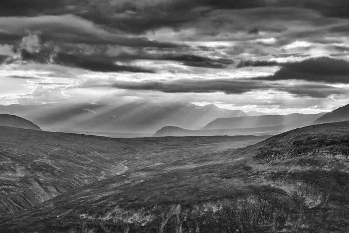 Framed Print : Sun rays fall through clouds in mountain landscape