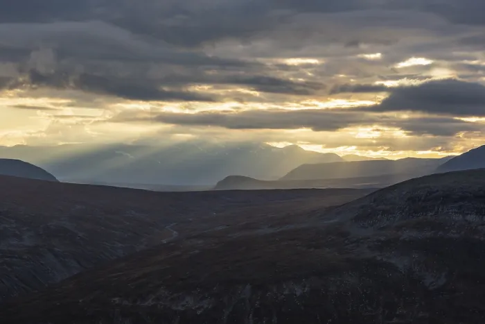 Framed Print : Sun rays fall through clouds in mountain landscape